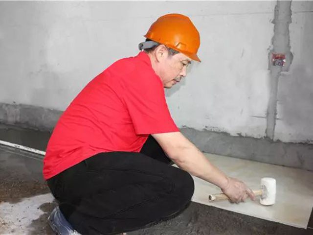 5鋪貼地磚時(shí)，磚的背面朝上批刮水泥油，并按箭頭所指方向統(tǒng)一鋪貼，用橡皮錘從中到邊，由重到輕敲實(shí).jpg